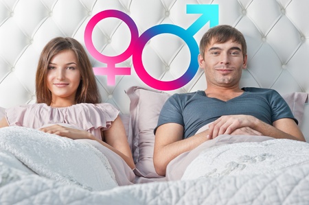 Young couple lying in their bed thinking about something. Gender graphic symbolsの写真素材