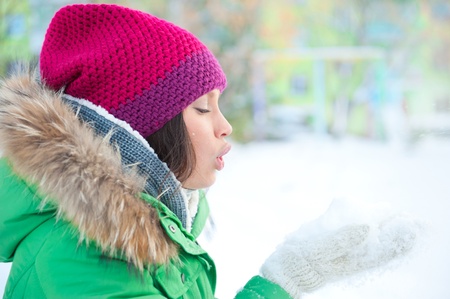Christmas Girl.Winter woman Blowing Snow. Side Viewの写真素材