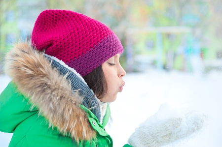 Christmas Girl.Winter woman Blowing Snow. Side Viewの写真素材