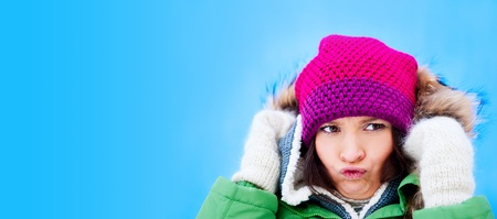 Beautiful Winter Woman outdoors against blue sky having fun and knitting her browsの写真素材