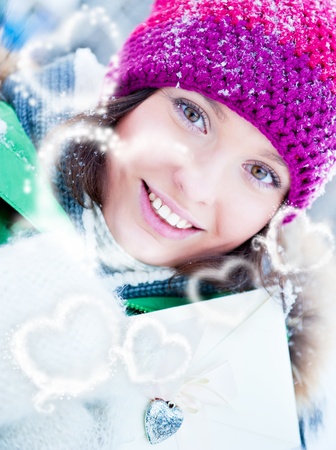 Young lady outdoors happily holding valentine gift and dreamingの写真素材