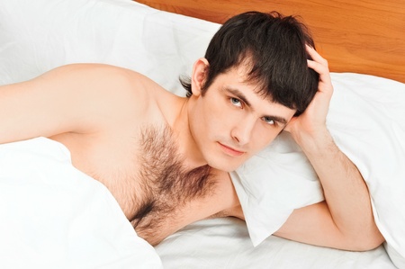 Man lying in bed smilingの写真素材