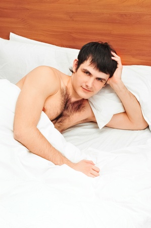 Man lying in bed smilingの写真素材