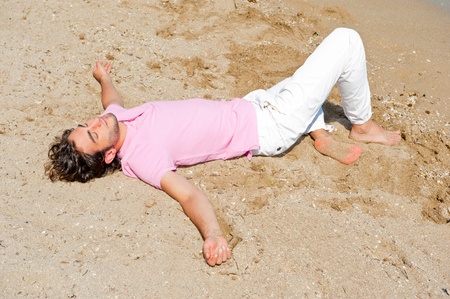 Portrait of attractive and happy man on the beach relaxing and daydreamingの写真素材
