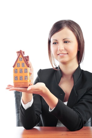 Portrait of young handsome woman holding house building in her arms. Isolated on white. Insurance  and mortgage conceptの写真素材