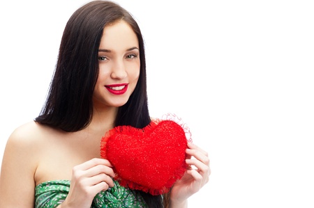 Cute young woman holds a heart symbol isolated on white backgroundの写真素材