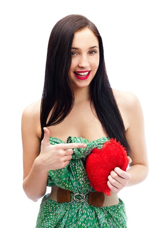 Cute young woman holds a heart symbol isolated on white backgroundの写真素材