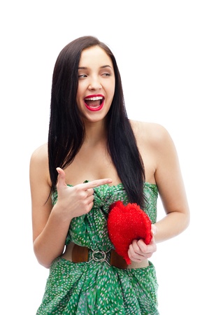 Cute young woman holds a heart symbol isolated on white backgroundの写真素材