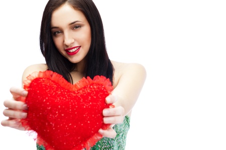 Cute young woman holds a heart symbol isolated on white backgroundの写真素材