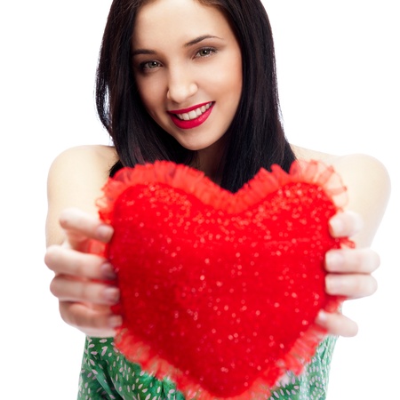 Cute young woman holds a heart symbol isolated on white backgroundの写真素材
