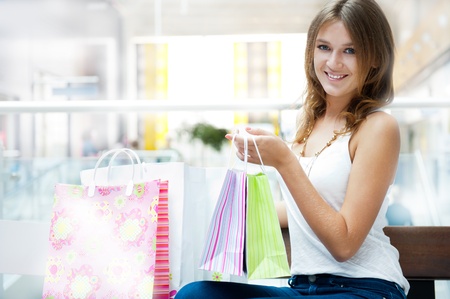 Happy shopping woman with bags and smiling. She is shopping inside mallの写真素材