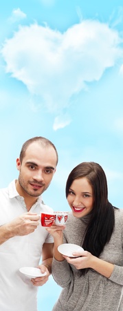 Portrait of young beautiful couple having tea or coffee beverage together at romantic backgroud with heart shapeの写真素材