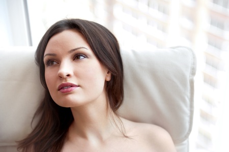 Portrait of smiling beautiful young brunette woman at homeの写真素材