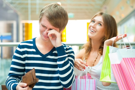 Woman can`t stop shopping at mall, making her man or boyfriend spent all his money and cryingの写真素材
