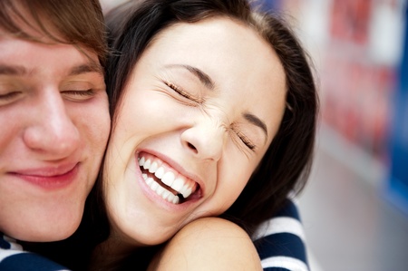 Young man meeting his girlfriend with opened arms at airport arrival hallの写真素材