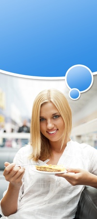 Portrait of young pretty smiling woman eating cake at shopping mall cafe. Blank graphic balloon with her thoughts with lots of copyspace for your text and logo overheadの写真素材