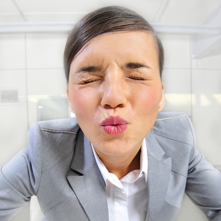 Closeup portrait of cute young business woman smiling and flirting sending air kissの写真素材