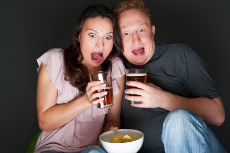 A couple watching a scary movie and it scared them so much that they are screaming.の写真素材