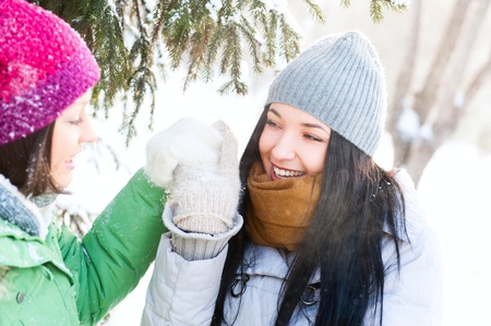 Two happy young girls having fun in winter parkの写真素材