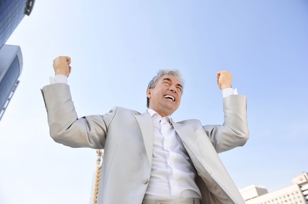Portrait of a businessman with arms open. Outside background.の写真素材