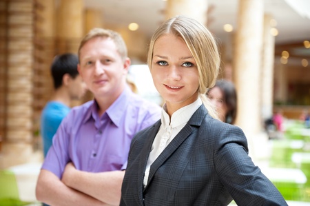  Portrait of a cute business woman with colleagues at the background. Indoors at modern office building centerの写真素材
