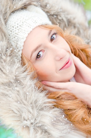 Portrait of pretty girl at winter background wearing warm clothes with furの写真素材