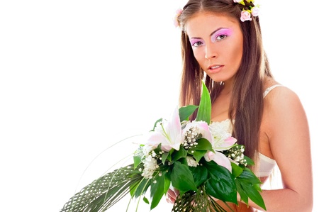 Closeup portrait of beautiful young woman wearing veil and wedding dress holding awesome bouquet of fresh liliesの写真素材