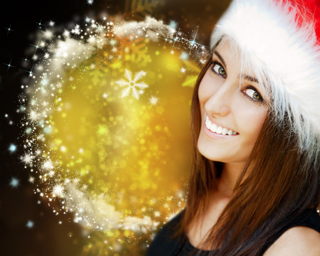 Beautiful woman wearing Santa Claus hat smiling to cameraの写真素材