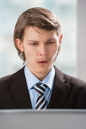 Happy business man viewing proposal email on laptopの写真素材