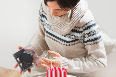 Portrait of a woman preparing to her husband or boyfriend surprise with a gift  - modern watch with timepiece on his birthday or valentine's day or another holidayの写真素材