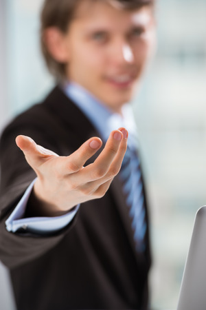 Portrait of adult business man pointing at you at his officeの写真素材
