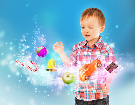 Little boy conjuring toys and confection with his handsの写真素材