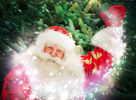 Portrait of Santa Claus conjuring against christmas treeの写真素材