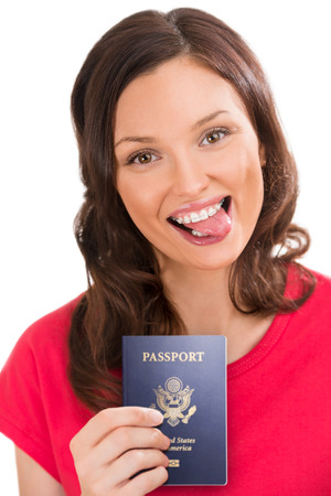Closeup portrait of young positive woman holding passport and showing tongueの写真素材