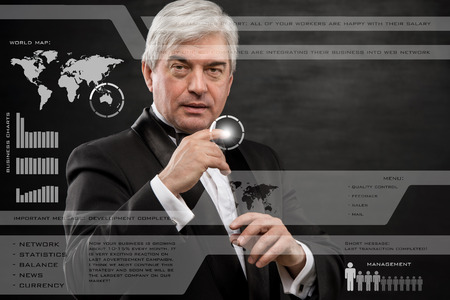 Businessman pressing high tech type of modern buttons on a virtual backgroundの写真素材