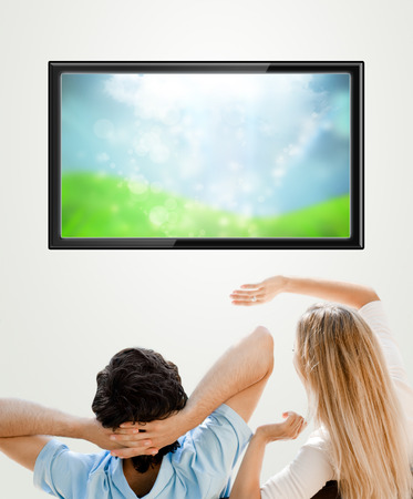 Young couple watching tv. Photo from behind. Lots of copyspaceの写真素材
