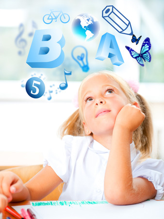 Portrait of a young girl studying. Different icons of lessons flying around herの写真素材