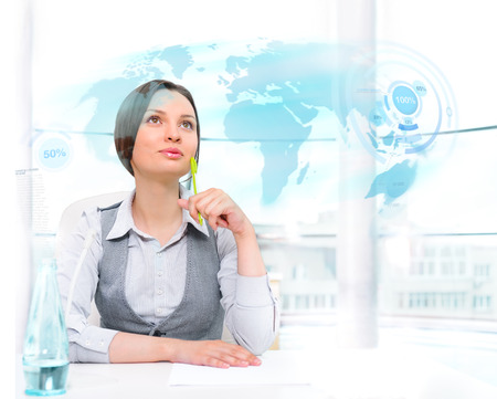 Businesswoman looking at high tech type of world map on a virtual backgroundの写真素材