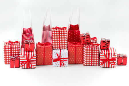Gift boxes with xmas presents wrapped in red paper with ornament on white backgroundの写真素材