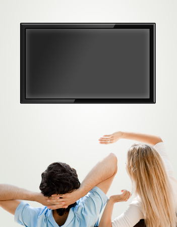 Young couple watching tv. Photo from behind. Lots of copyspaceの写真素材