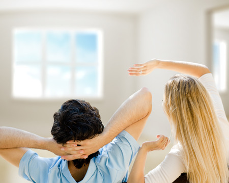 Cosy young couple embracing inside new apartment and planning to buy it. Mortgage and new home conceptの写真素材