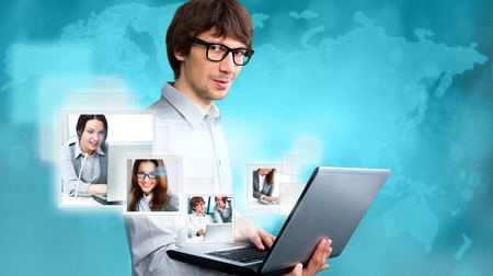 Adult businessman using his tablet computer to communicate his team. Virtual meeting technology for global business concept.の写真素材