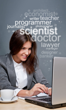 Young business woman looking for staff of different professions using her laptopの写真素材