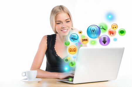 Young woman using her laptop for multimedia and site surfing. Different icons appearing from the screenの写真素材
