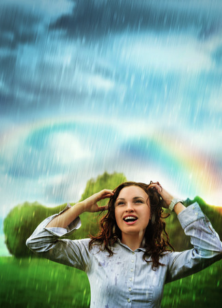 Young woman under storm rain. She is happy and wetの写真素材