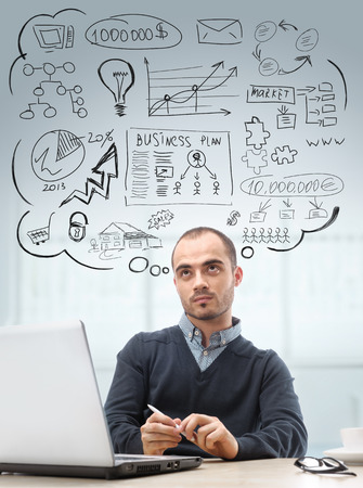 Young business man sitting at office looking up and planning  Graphic sketch style thoughts overheadの写真素材