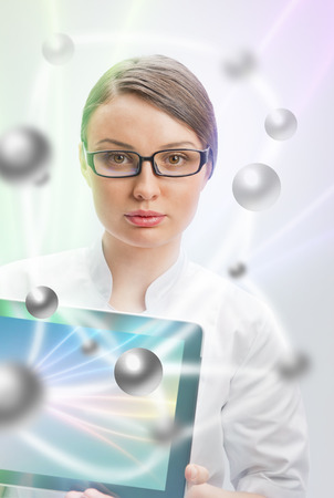 Young woman doctor in white coat  holding digital tablet pc with technology collageの写真素材