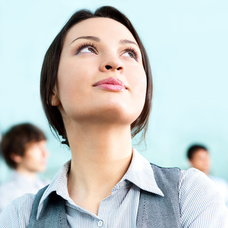 Portrait of a cute business woman with colleagues at the background. Indoors at modern office building centerの写真素材
