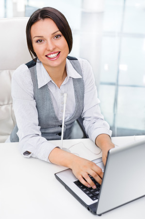 Smiling pretty business woman with microphone. She is salesperson or support team workerの写真素材