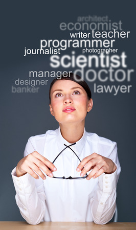 Young businesswoman sitting at her office and thinking about staff she need or about future professionの写真素材